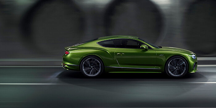  Bentley Mougins Bentley Continental GT coupe in Tourmaline Green paint driving in profile on a dark road