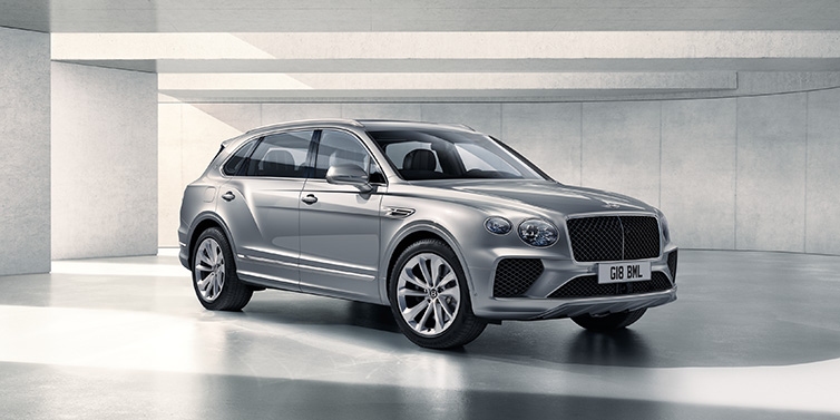 Bentley Mougins Bentley Bentayga Extended Wheelbase SUV front three quarter in Moonbeam paint with a grey background