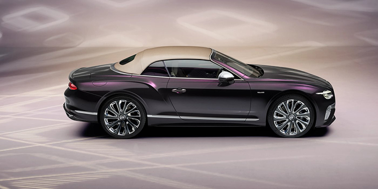 Bentley Mougins Bentley Continental GTC Mulliner convertible in profile with hood up, in Tanzanite Purple paint and 22 inch Mulliner painted and polished wheels