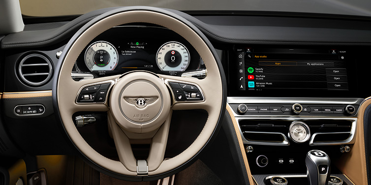 Bentley Mougins Bentley Flying Spur Mulliner sedan front interior detail of steering wheel and driver screens surrounded by Linen and Beluga black hides